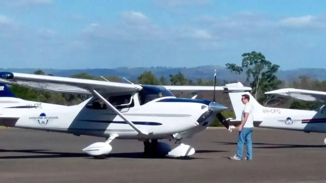Mauricio Castellanos standing beside a Cessna aircraft at an airfield